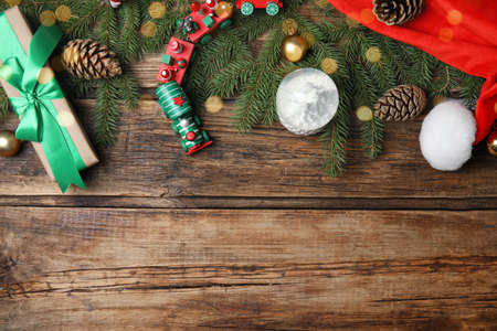 Christmas greeting card with space for text. Flat lay composition of fir tree branches and festive decor on wooden backgroundの写真素材