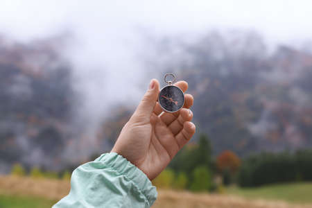 Woman using compass for navigation during journey in mountains, closeupの写真素材