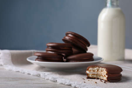 Tasty choco pies and milk on white wooden tableの写真素材