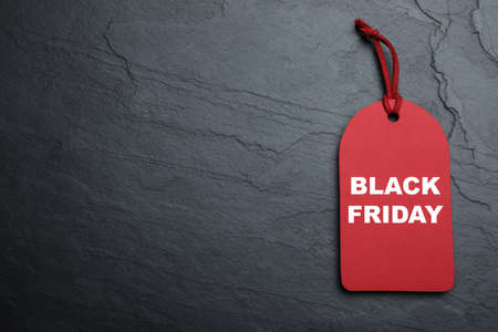 Red tag with words Black Friday on dark stone background, top view. Space for textの写真素材