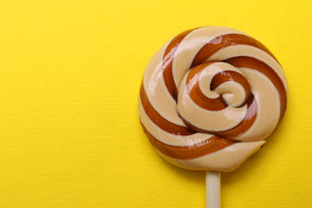 Delicious lollipop on yellow background, top view. Space for textの写真素材