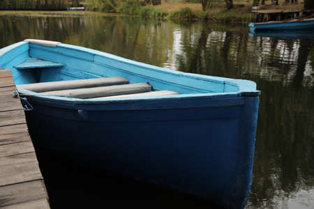 Light blue wooden boat on lake near pier, closeupの写真素材