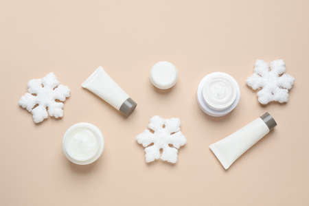Flat lay composition with cosmetic products and snowflakes on beige background. Winter skin careの写真素材
