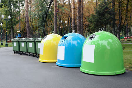 Waste sorting bins in park on autumn day