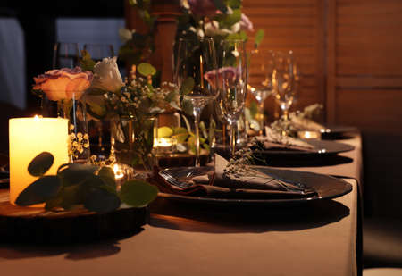 Elegant table setting with beautiful floral decor and burning candlesの写真素材