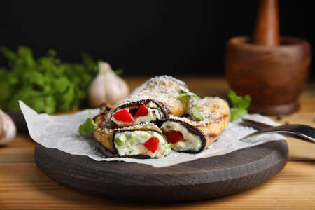Delicious baked eggplant rolls served on wooden tableの写真素材