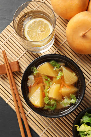 Bowl of tasty turnip soup served on table, flat lay