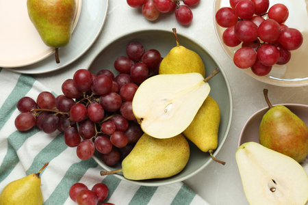Fresh ripe pears and grapes on light gray table, flat layの写真素材