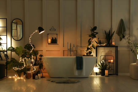 Stylish bathroom interior with houseplants and string lights. Home design