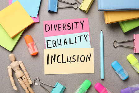 Words Diversity Equality Inclusion and stationery on gray background, flat layの写真素材