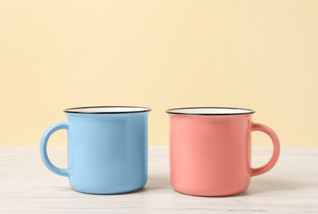 Blue and pink mugs on white wooden table. Gender equalityの写真素材