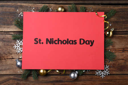Red card with text St. Nicholas Day and festive decor on wooden table, flat layの写真素材