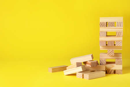 tower and wooden blocks on yellow background, space for textの写真素材