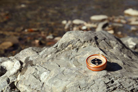Compass on rock outdoors. Space for textの写真素材