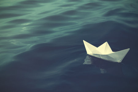 White paper boat floating on river. Retro photo effectの写真素材
