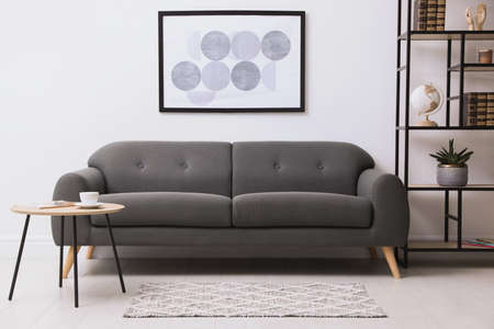 Stylish living room interior with gray rug, comfortable sofa and plantの写真素材