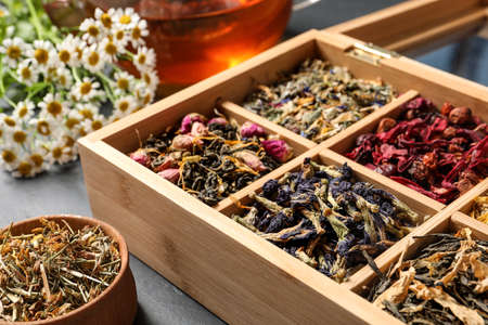 Different dry teas and chamomile flowers on table, closeupの写真素材
