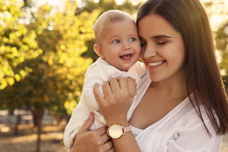 Young mother with her cute baby in park on sunny dayの写真素材