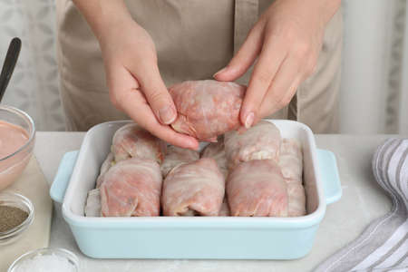 Woman making stuffed cabbage rolls at table, closeupの写真素材
