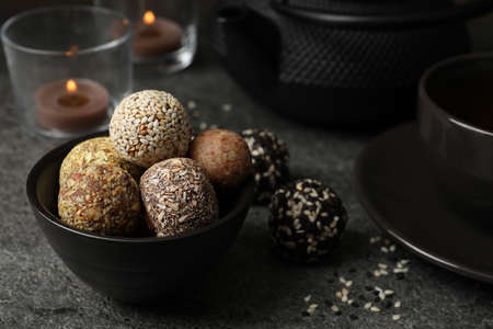 Different delicious vegan candy balls on gray table
