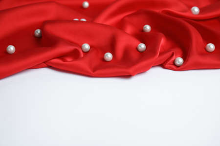 Texture of delicate red silk with pearls on white backgroundの写真素材