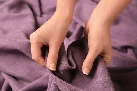 Woman touching soft purple fabric, closeup view