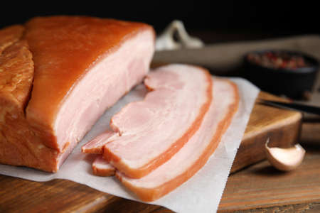 Delicious smoked bacon and garlic on wooden table, closeupの写真素材