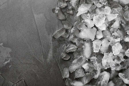 Pile of crushed ice on gray table, top view. Space for textの写真素材