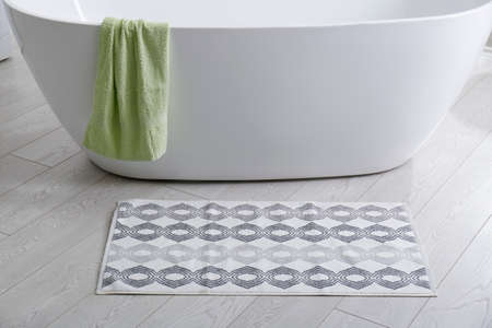 Stylish mat on floor near tub in bathroom. Interior designの写真素材