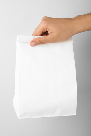 Woman holding paper bag on white background, closeupの写真素材