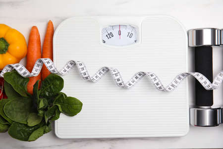 Flat lay composition with scales and vegetables on white marble table,の写真素材