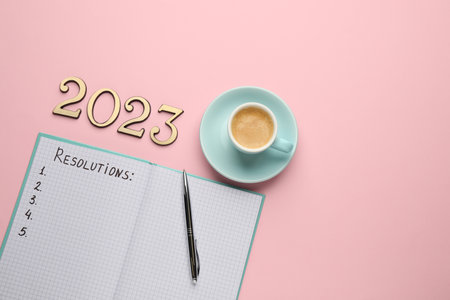 Making resolutions for 2023 New Year. Flat lay composition with notebook on pink background