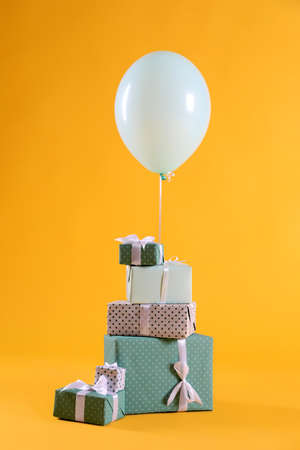 Many gift boxes and balloon on yellow backgroundの写真素材