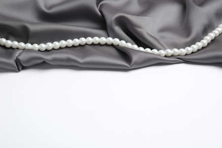 Beautiful pearls and gray silk on white backgroundの写真素材