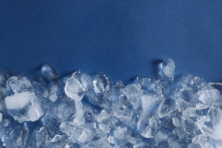 Pile of crushed ice on blue background, top view. Space for textの写真素材