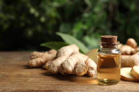 Ginger essential oil in bottle on wooden table. Space for textの写真素材