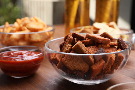 Crispy rusks and dip sauce on wooden table, closeupの写真素材