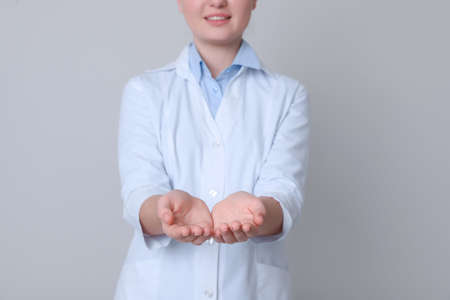 Dental assistant holding something on light gray background, closeupの写真素材