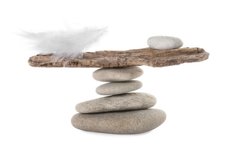 Stack of stones with tree branch and feather on white background. Balance conceptの写真素材