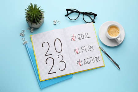 Flat lay composition of notebook with text 2023 Goal, Plan, Action on light blue background. New Year aimsの写真素材