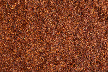 Heap of dry rooibos tea leaves as background, top viewの写真素材