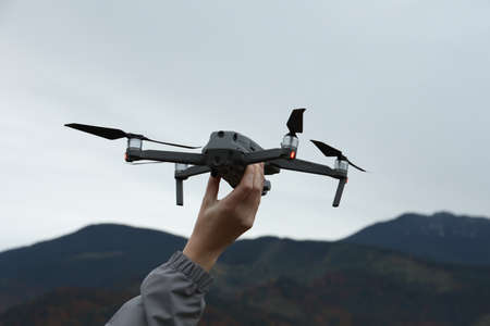 Woman with modern drone in mountains, closeupの写真素材