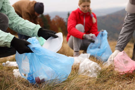 People with trash bags collecting garbage in natureの写真素材