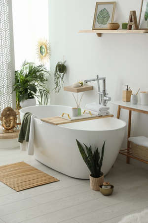 Stylish bathroom interior with modern tub, houseplants and beautiful decor. Home designの写真素材