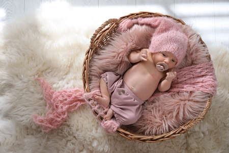 Adorable newborn baby with pacifier in wicker basket, top viewの写真素材