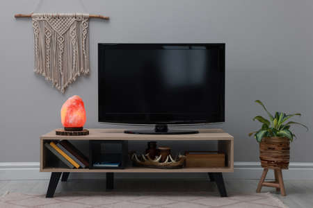 Stylish room interior with TV set, himalayan salt lamp and decor elementsの写真素材