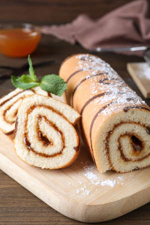 Tasty cake roll with jam on wooden tableの写真素材