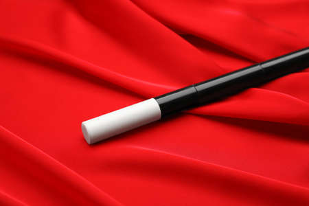 Beautiful black magic wand on red fabric, closeupの写真素材