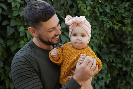Happy father with his little baby outdoors on sunny day