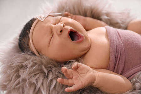 Cute newborn baby yawning on fuzzy blanket closeupの写真素材